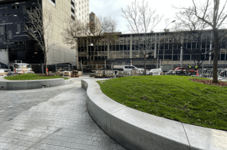 Gently curved granite edging used for public seating and defining green lawn spaces in a modern Australian city plaza